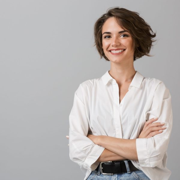 Image of happy young business woman posing isolated over grey wall background.